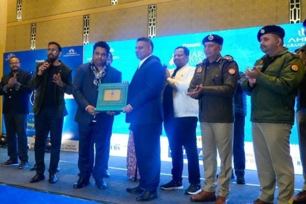 Rohit Jain among a line of people on stage with police officers, each holding a framed plaque.