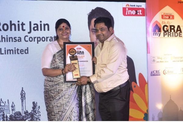 A framed certificate being presented to Rohit Jain in front of a Dainik Jagran i-next backdrop.
