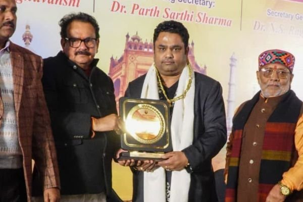 Rohit Jain holding a large medallion plaque between two guests at the All India Homeopathy seminar.