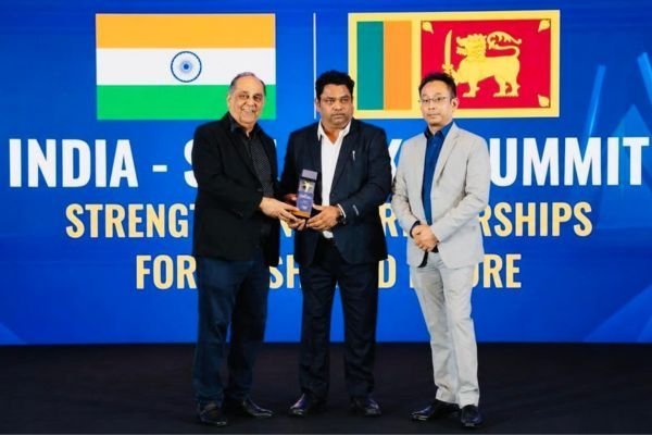 Rohit Jain accepting a trophy in front of a screen reading India&ndash;Sri Lanka Summit, with both national flags.