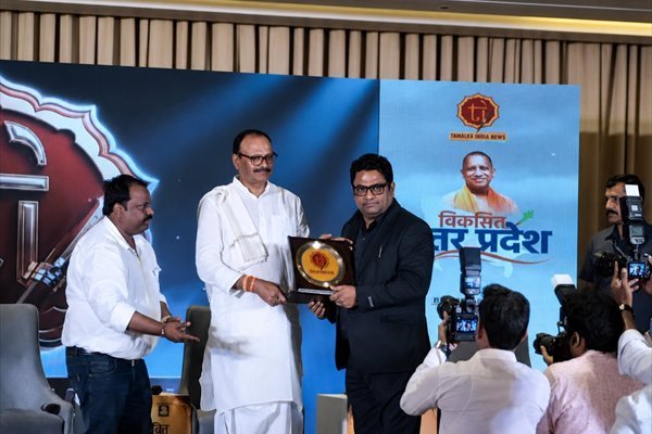Rohit Jain being handed a framed certificate on stage at the Viksit Uttar Pradesh Conclave in Lucknow.
