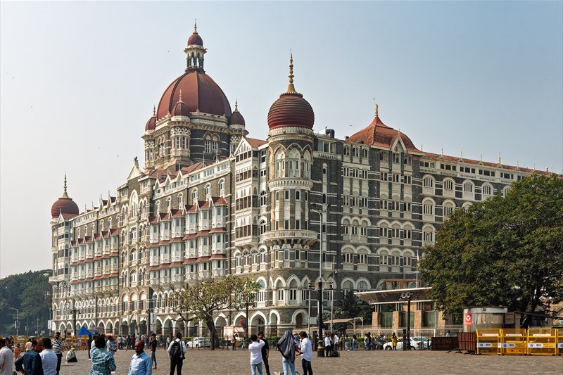 The Taj Mahal Palace hotel in Mumbai, its red domes seen from the Gateway of India forecourt.