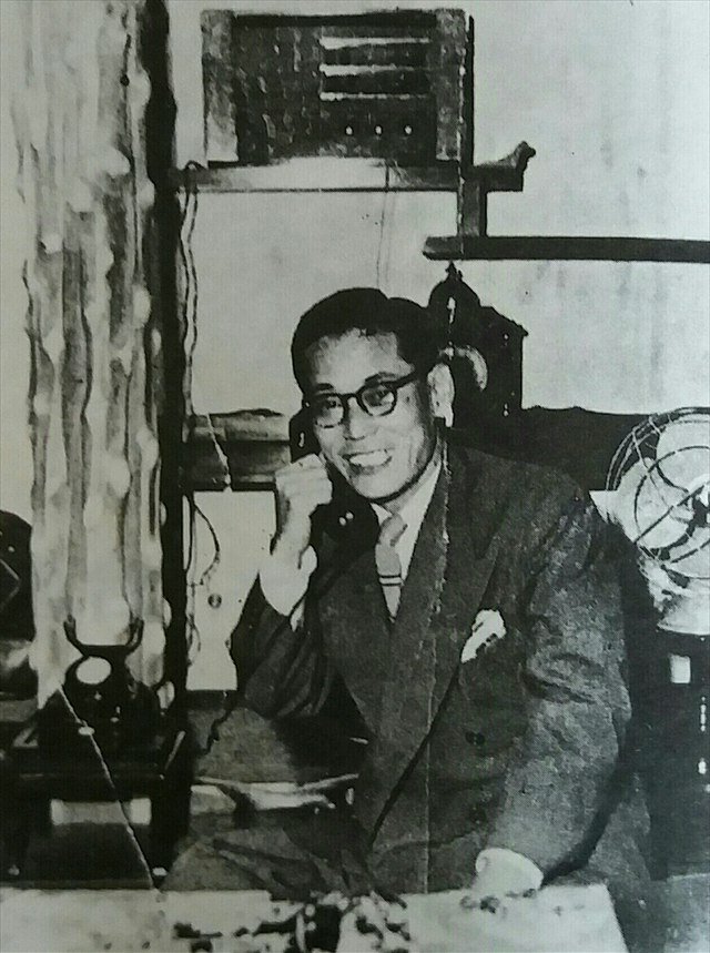 Lee Byung-chul, Samsung’s founder, seated at a desk beside a telephone in an early black-and-white photograph.