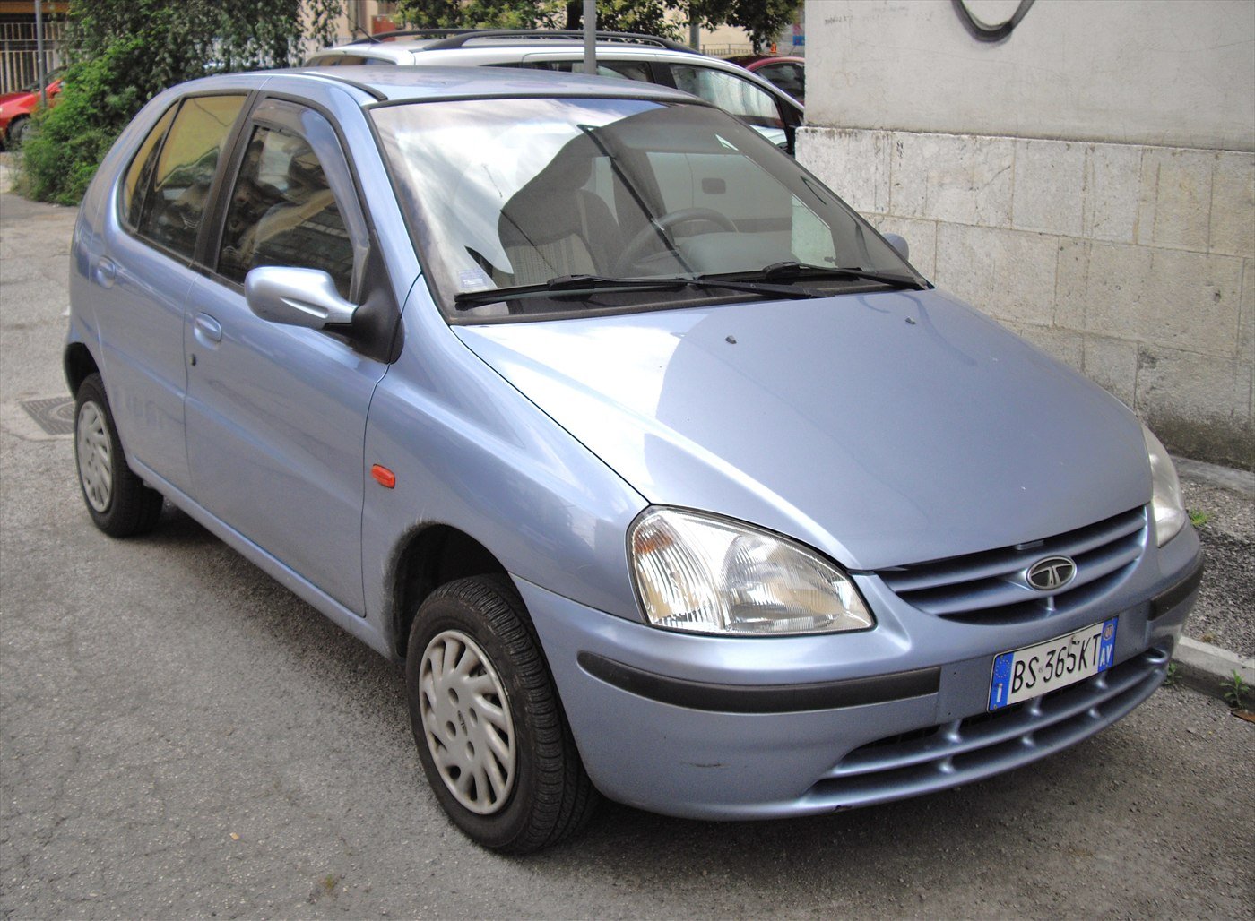 An early silver-blue Tata Indica hatchback parked on a street.
