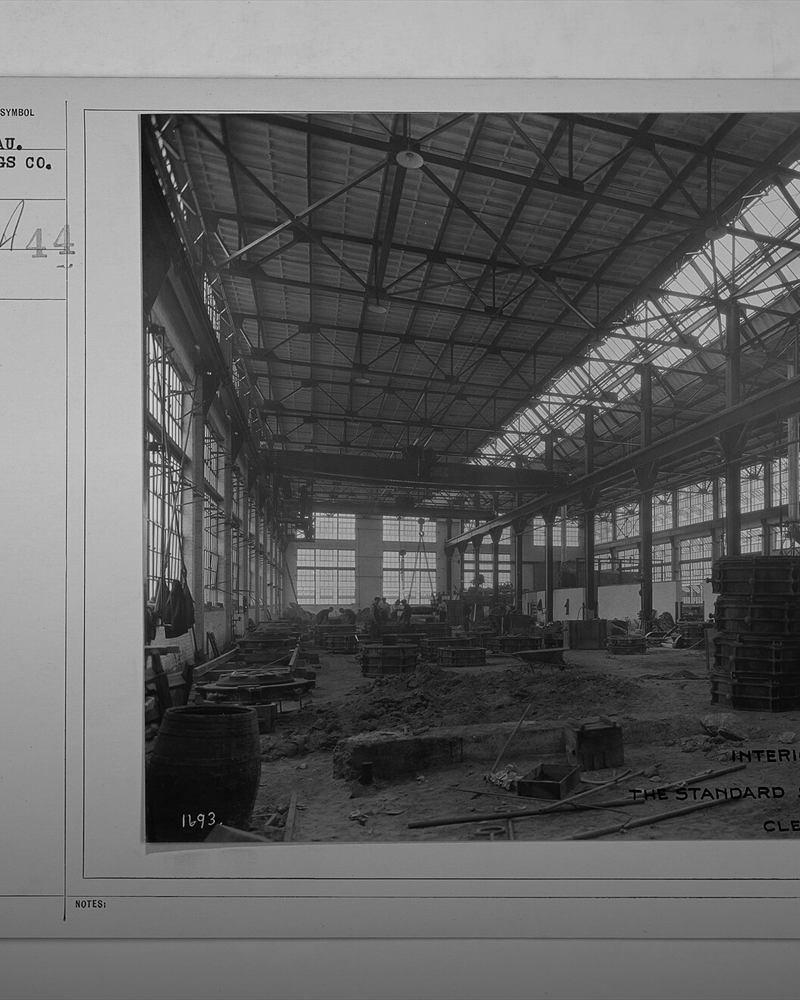 The interior of a mill, belt-driven machinery running the length of the floor.